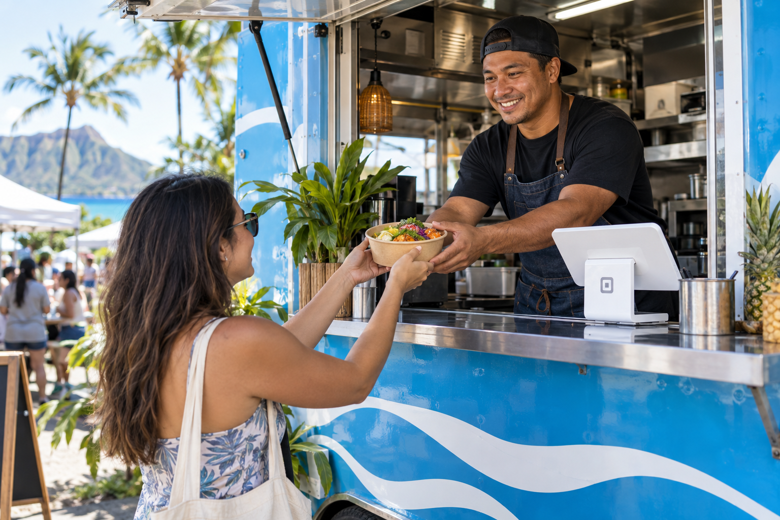 Food truck owner serving a customer with a compact POS at the counter